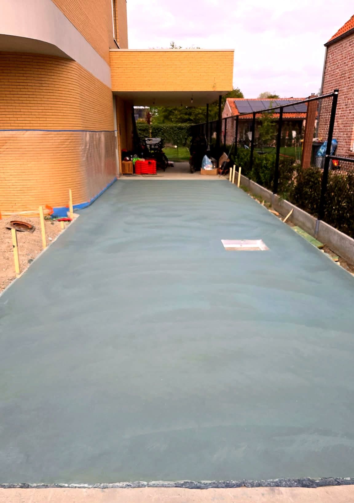 Nieuw gegoten betonnen oprit naast een woning